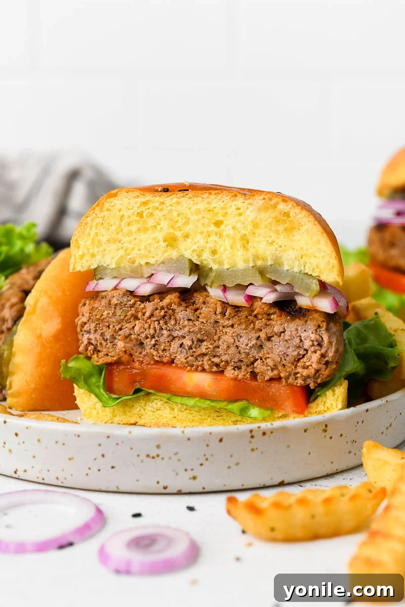 Gourmet Burgers at Home 6 A delicious homemade beef burger cut in half, showcasing its juicy interior, served with fries and a drink.