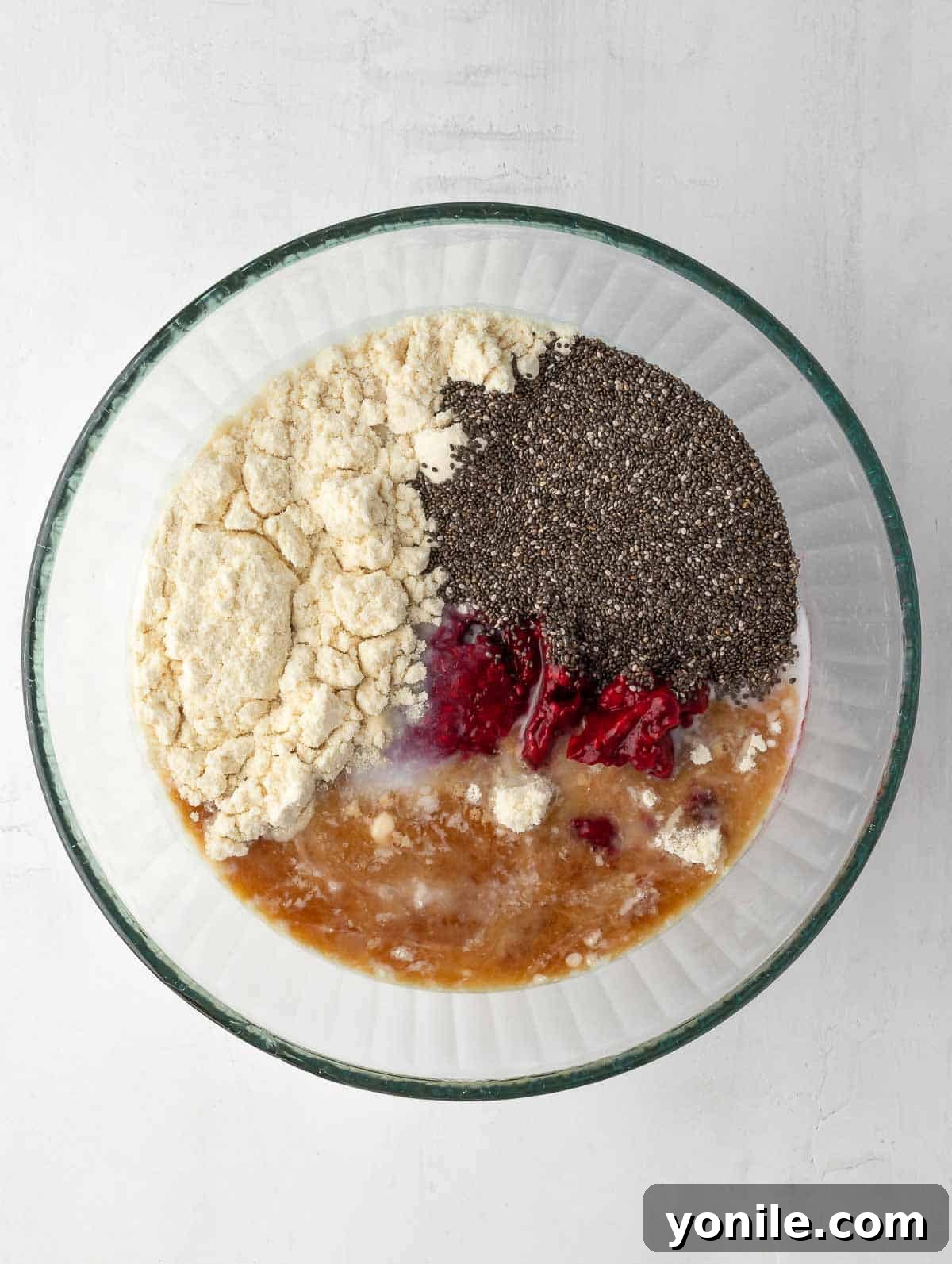 Raspberry protein chia pudding ingredients placed in a bowl, ready for mixing.