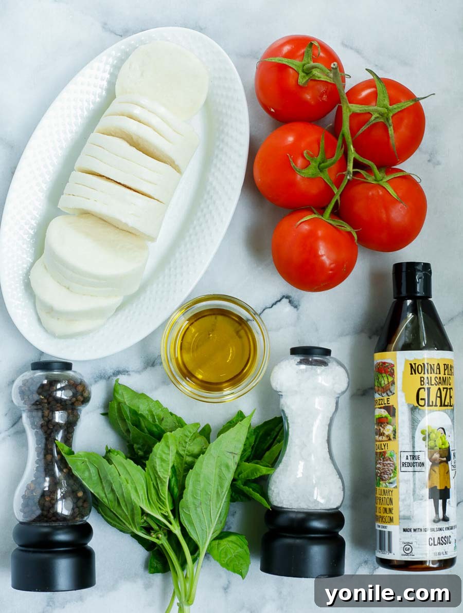 ingredient shot of the caprese tomato salad featuring fresh tomatoes, mozzarella, basil, olive oil, and balsamic glaze