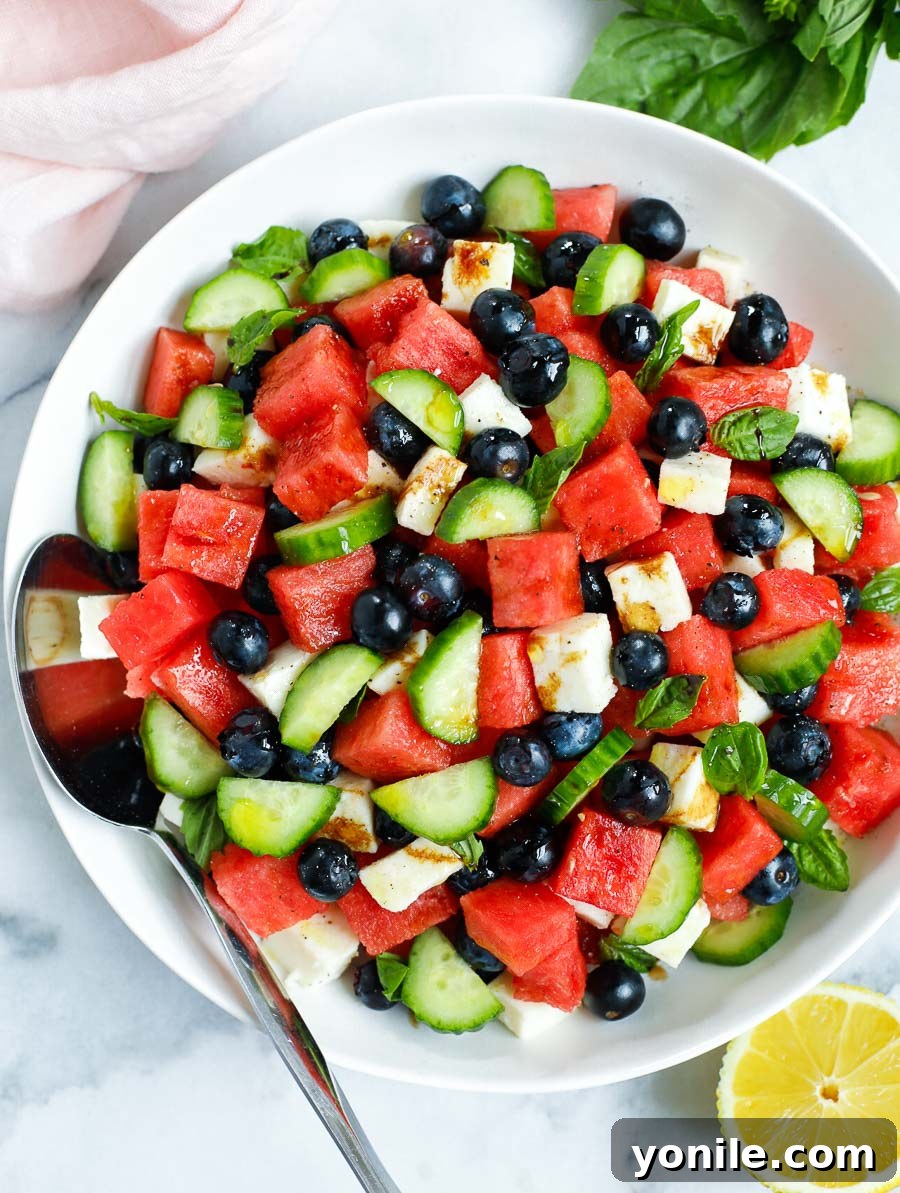 top down shot of watermelon feta salad in a bowl with a spoon, highlighting fresh ingredients