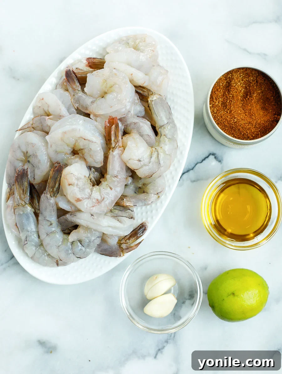 All the fresh ingredients for a Chipotle Shrimp Bowl laid out on a table, including shrimp, limes, spices, and various colorful vegetables.