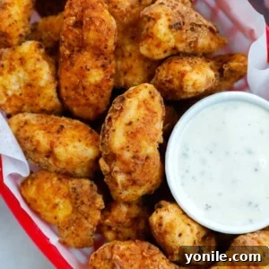 Crispy chicken bites in a red basket with a side of ranch