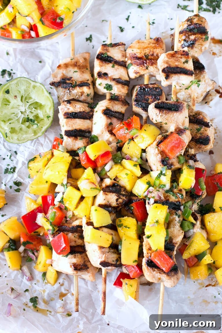 Easy Grilled Mango Chicken Skewers with a fresh mango and pepper salsa are deliciously juicy and packed with flavor. These are great for dinner! #grilledchicken #chicken #mango #chickenkabob