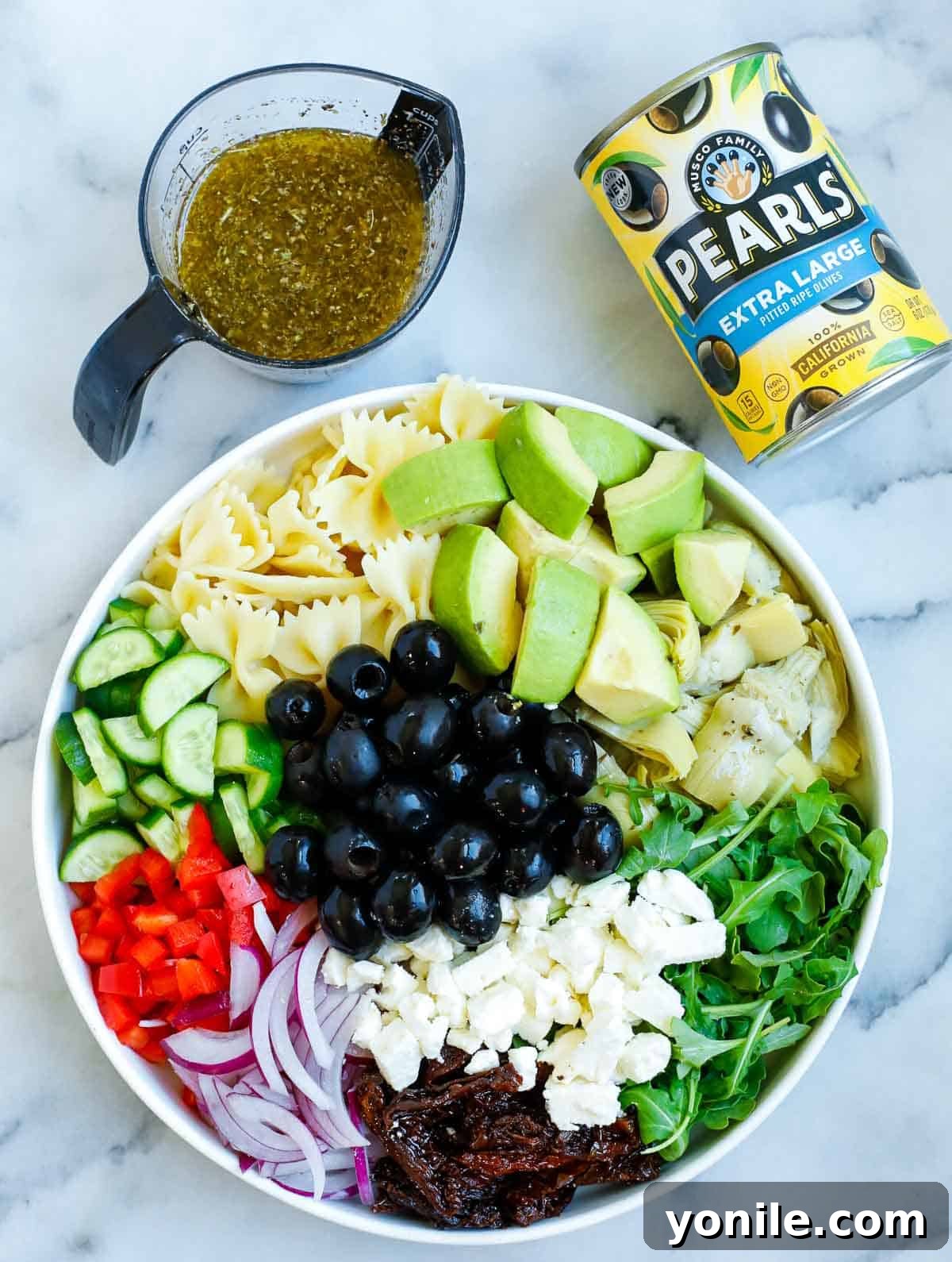Zesty Mediterranean Pasta Salad 6 Ingredients for the pasta salad in a bowl before adding the dressing.