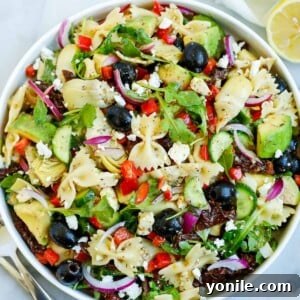 lemon herb Mediterranean salad served in a white bowl, with a side of lemon
