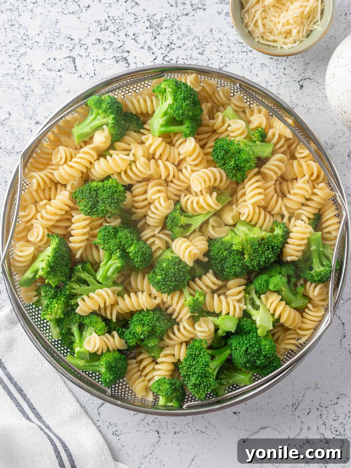 Homestyle Baked Chicken and Broccoli Pasta 4 Close-up of steamed broccoli and cooked pasta in a colander, illustrating the combination step.