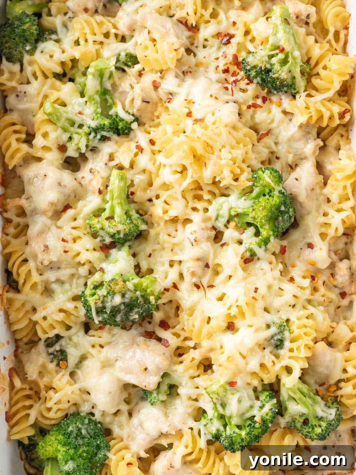 Homestyle Baked Chicken and Broccoli Pasta 9 A close-up shot showcasing the creamy, cheesy texture of the baked chicken and broccoli pasta bake, with tender chicken and vibrant broccoli visible throughout the dish.
