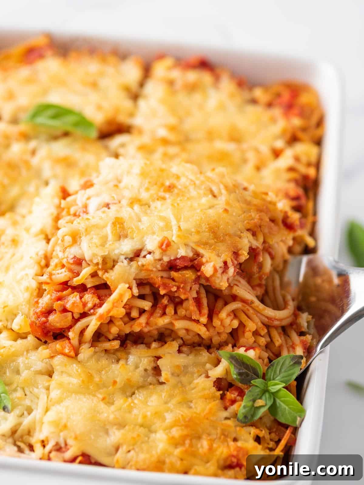 Simple Baked Spaghetti Casserole 2 Spatula lifting out a portion of the baked spaghetti, showcasing the melted cheese and rich sauce.