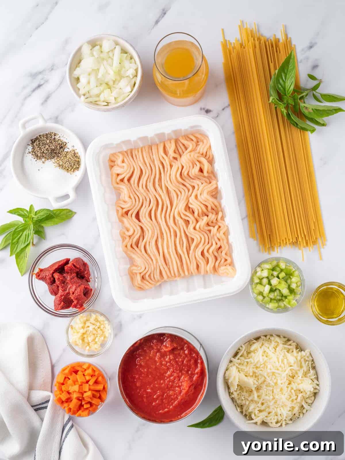 Simple Baked Spaghetti Casserole 3 A selection of fresh ingredients including vegetables, ground chicken, and canned tomatoes, ready for the baked spaghetti.