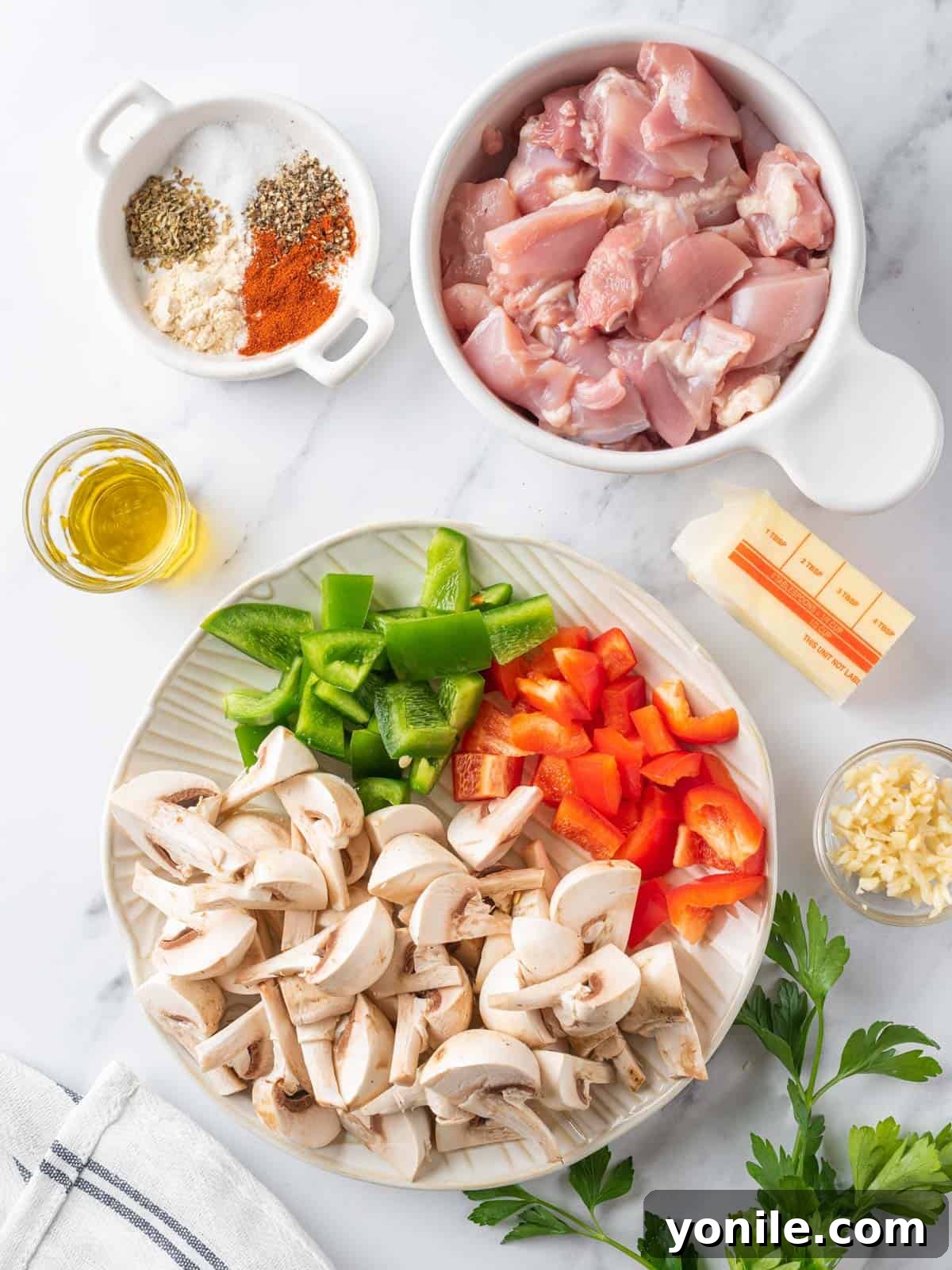 Sizzling Garlic Butter Mushroom Chicken Bites 3 Ingredients laid out for making Garlic Mushroom Chicken Bites, including chicken, mushrooms, bell peppers, garlic, butter, and seasonings.