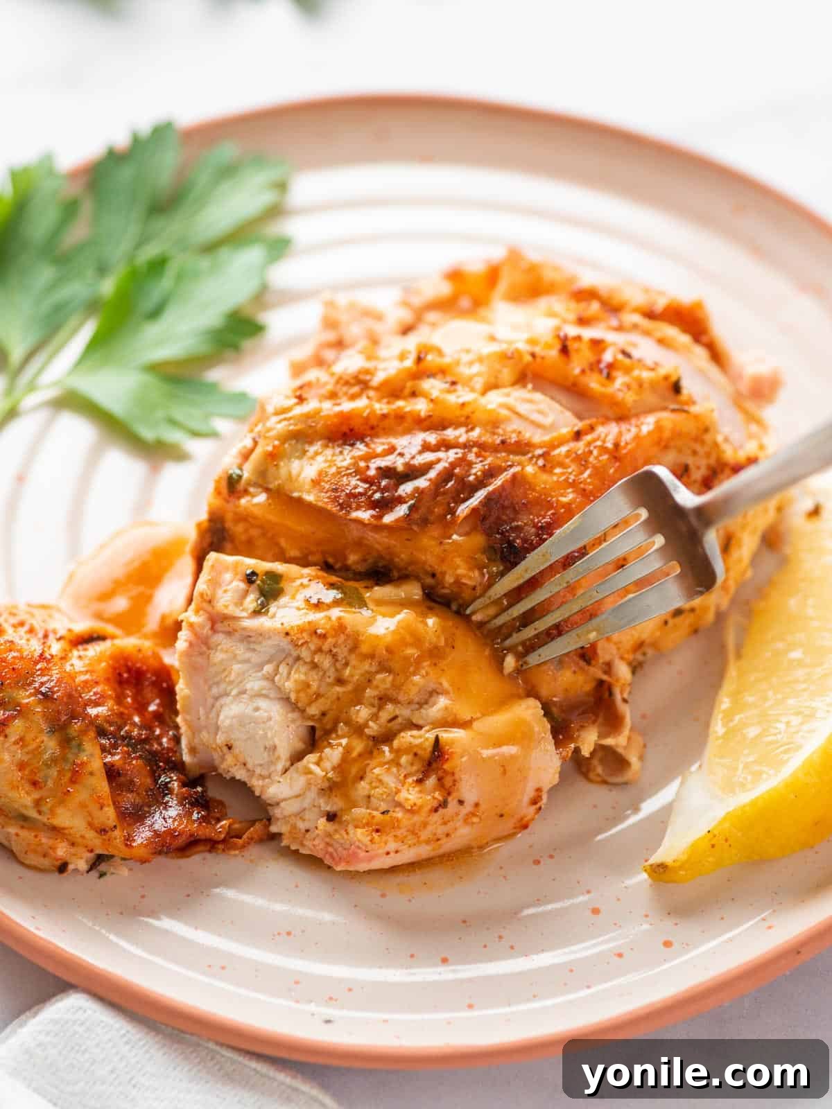 Succulent Spatchcock Roast Chicken 13 A close-up of a perfectly cooked spatchcock chicken breast, sliced and tested with a fork to show its juiciness and tenderness.