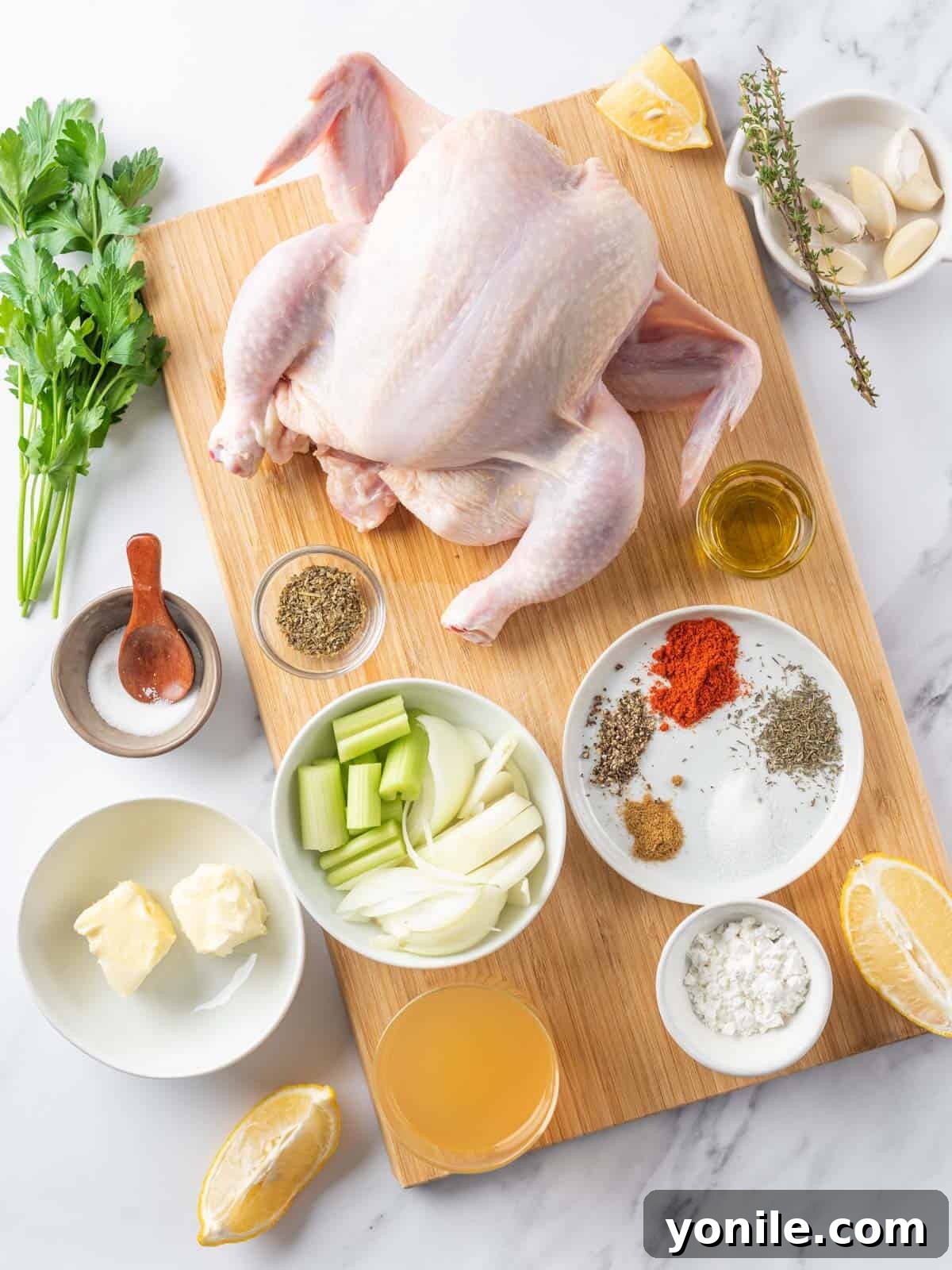 Succulent Spatchcock Roast Chicken 3 A collection of fresh ingredients laid out, including butter, herbs, garlic, and various spices for the spatchcock chicken.