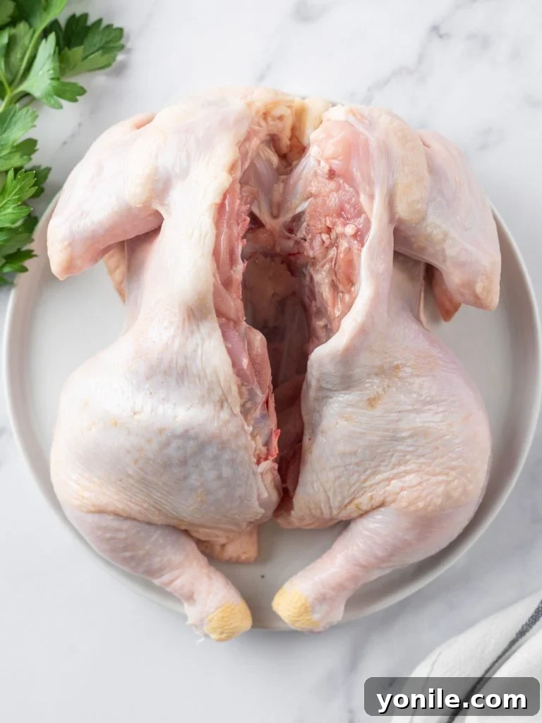 Succulent Spatchcock Roast Chicken 7 The chicken with its spine removed, laid flat on a cutting board, showcasing the spatchcocked preparation.