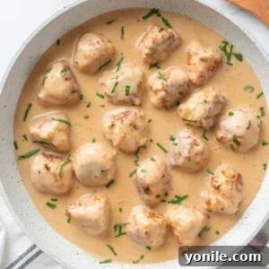 A pan of chicken Swedish meatballs with creamy sauce.