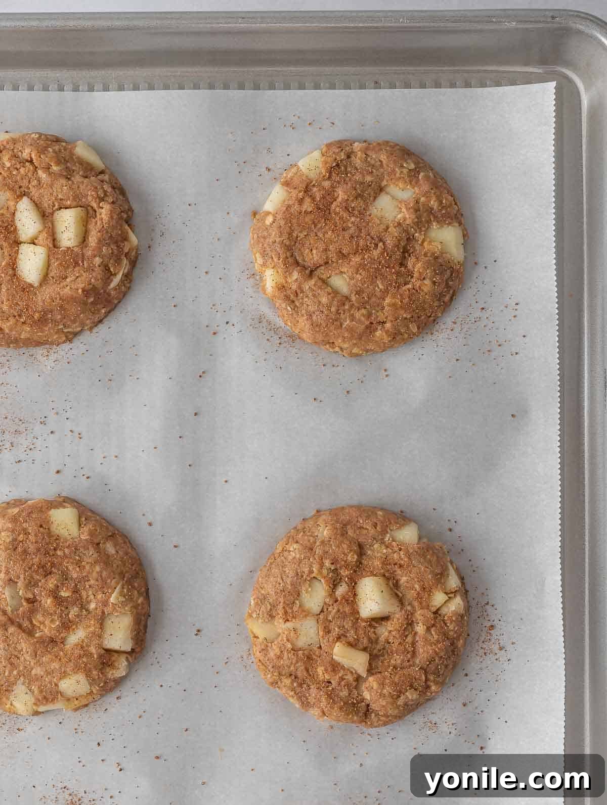 A baking sheet with unbaked apple pie oatmeal cookie dough, ready for the oven.
