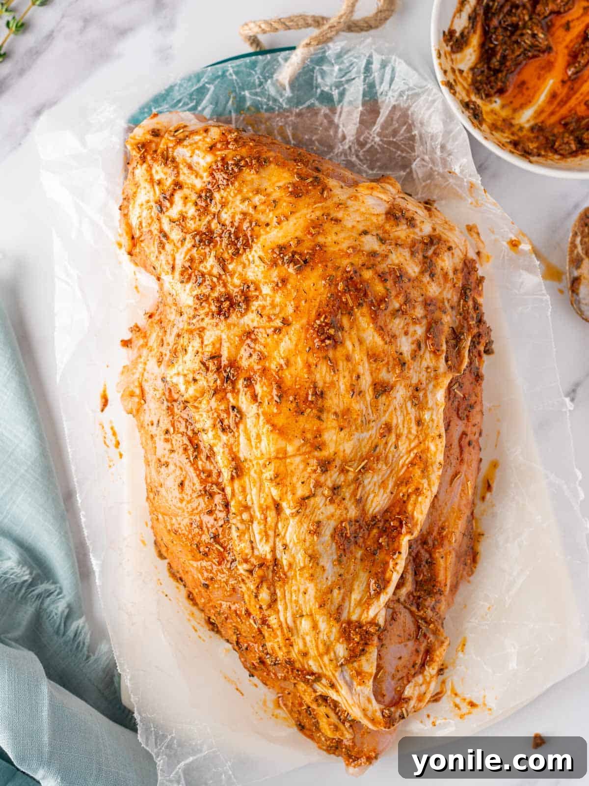 Perfectly Roasted Boneless Turkey Breast 5 raw turkey breast after being thoroughly rubbed with the savory seasoning paste, showcasing an even coating under and over the skin