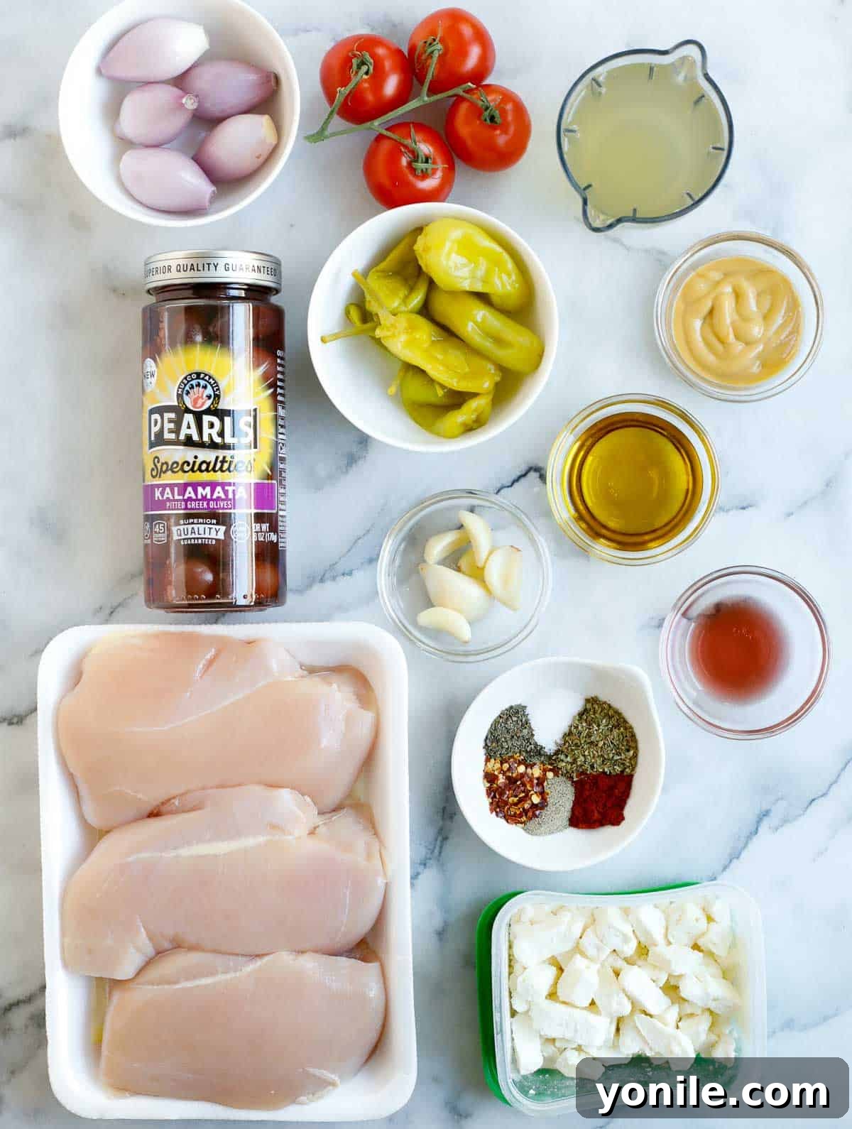 Ingredients needed to make oven baked Greek chicken, laid out on a table.