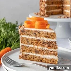 A slice of moist carrot cake on a plate with a fork.