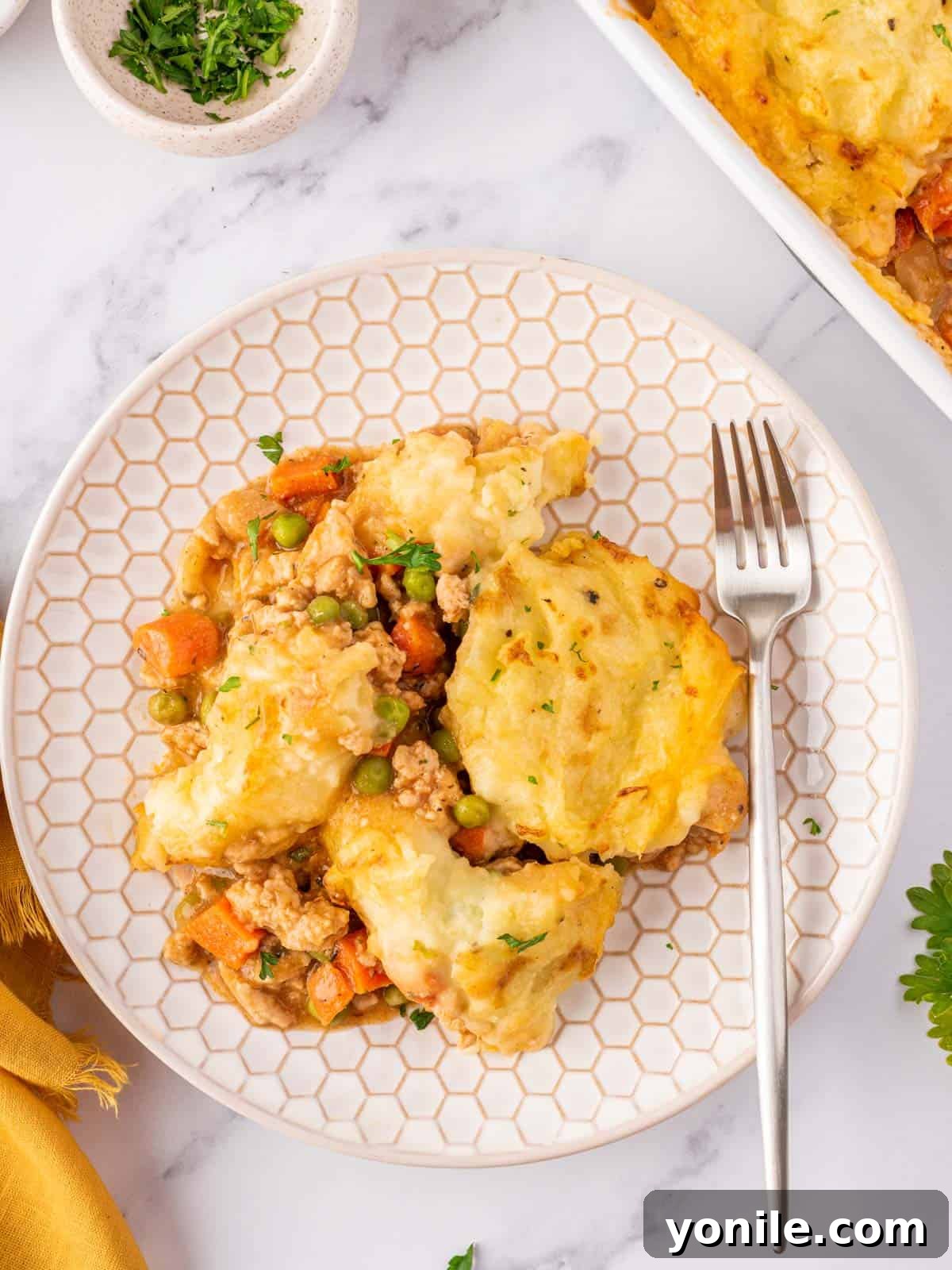 A generous slice of Chicken Shepherd's Pie served on a plate, showcasing its golden mashed potato topping and rich filling