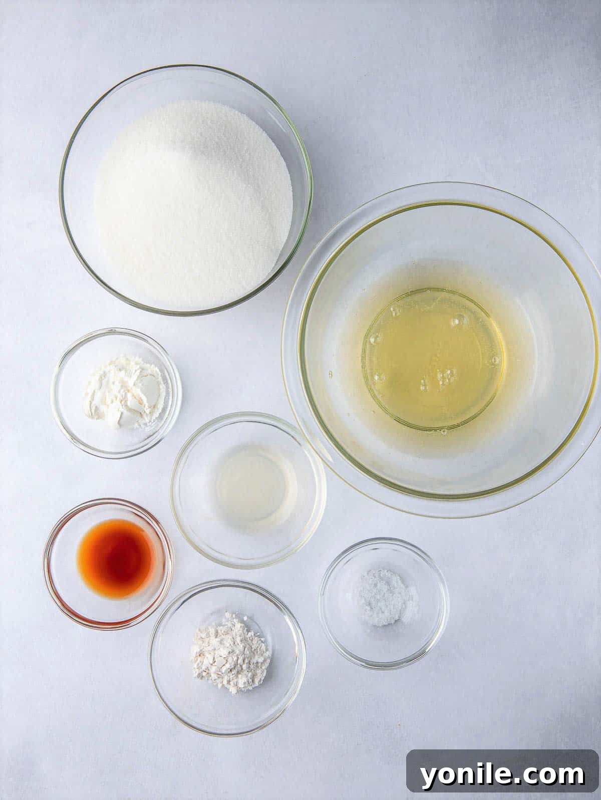 Various ingredients for a Berry Pavlova Cake laid out on a kitchen counter, including eggs, sugar, and cream of tartar.