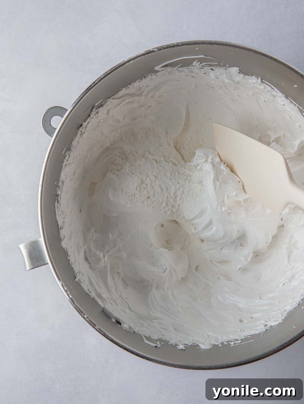 A perfectly whipped, glossy meringue in a mixing bowl, ready for shaping.