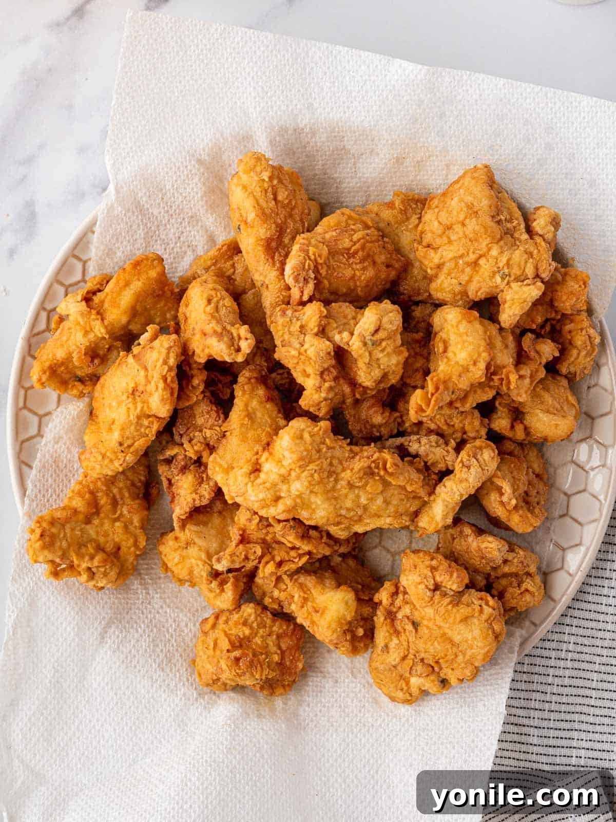 Zesty Lemon Chicken 5 Crispy fried chicken draining on a paper towel.