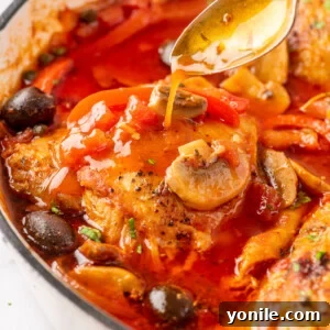 Close up photo of easy chicken cacciatore in a skillet, showcasing the rich sauce and tender chicken.