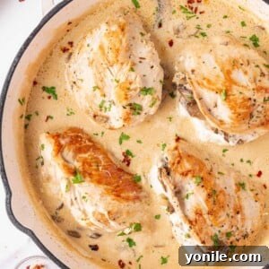 Mushroom Stuffed Chicken Breast in a white skillet with a creamy sauce.