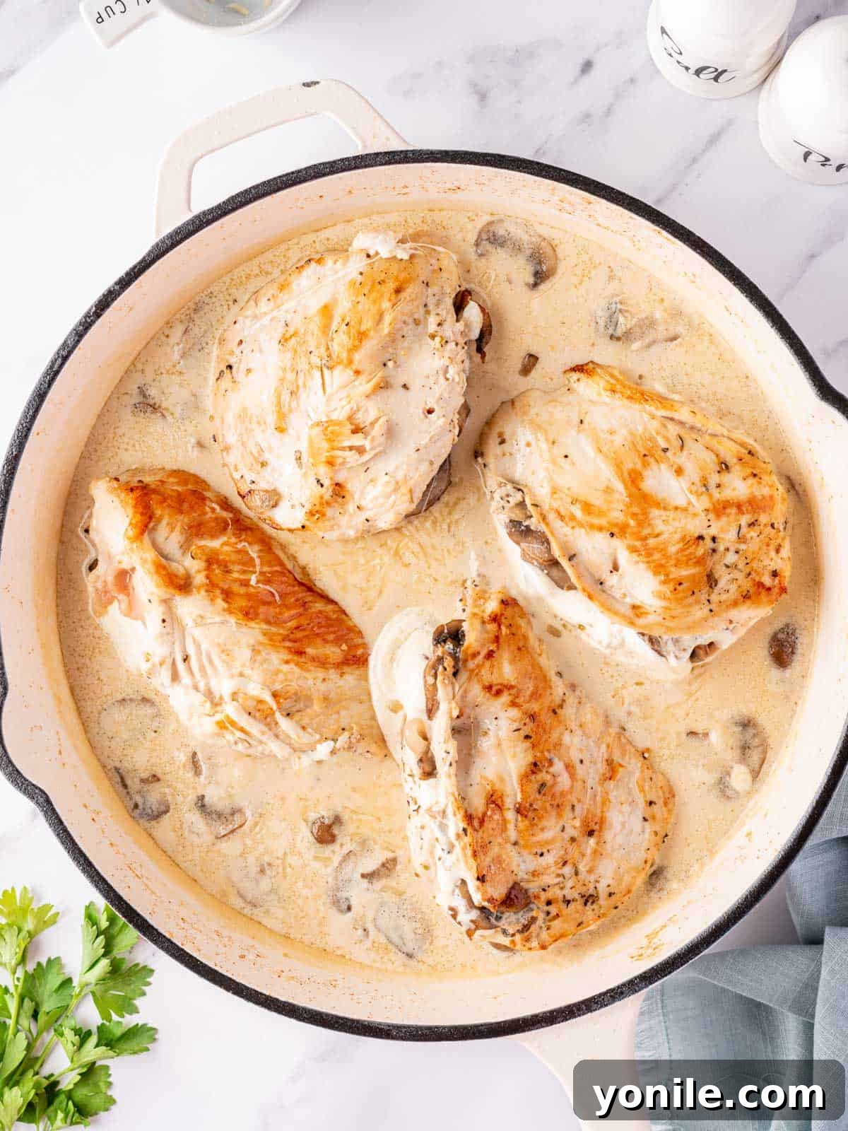 Garlic butter mushroom stuffed chicken in a skillet.