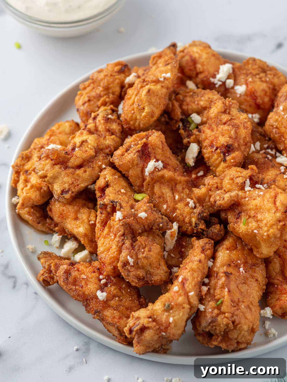 KFC's Fiery Nashville Tenders 2 A plate of Nashville hot chicken tenders with crumbled cheese and pickles.