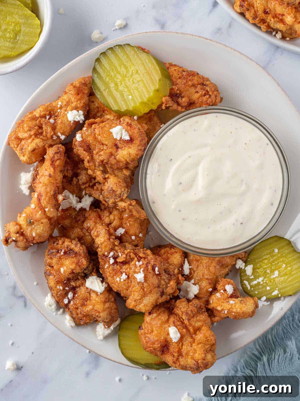KFC's Fiery Nashville Tenders 11 A plate of Nashville hot chicken tenders with pickles and dipping sauce.