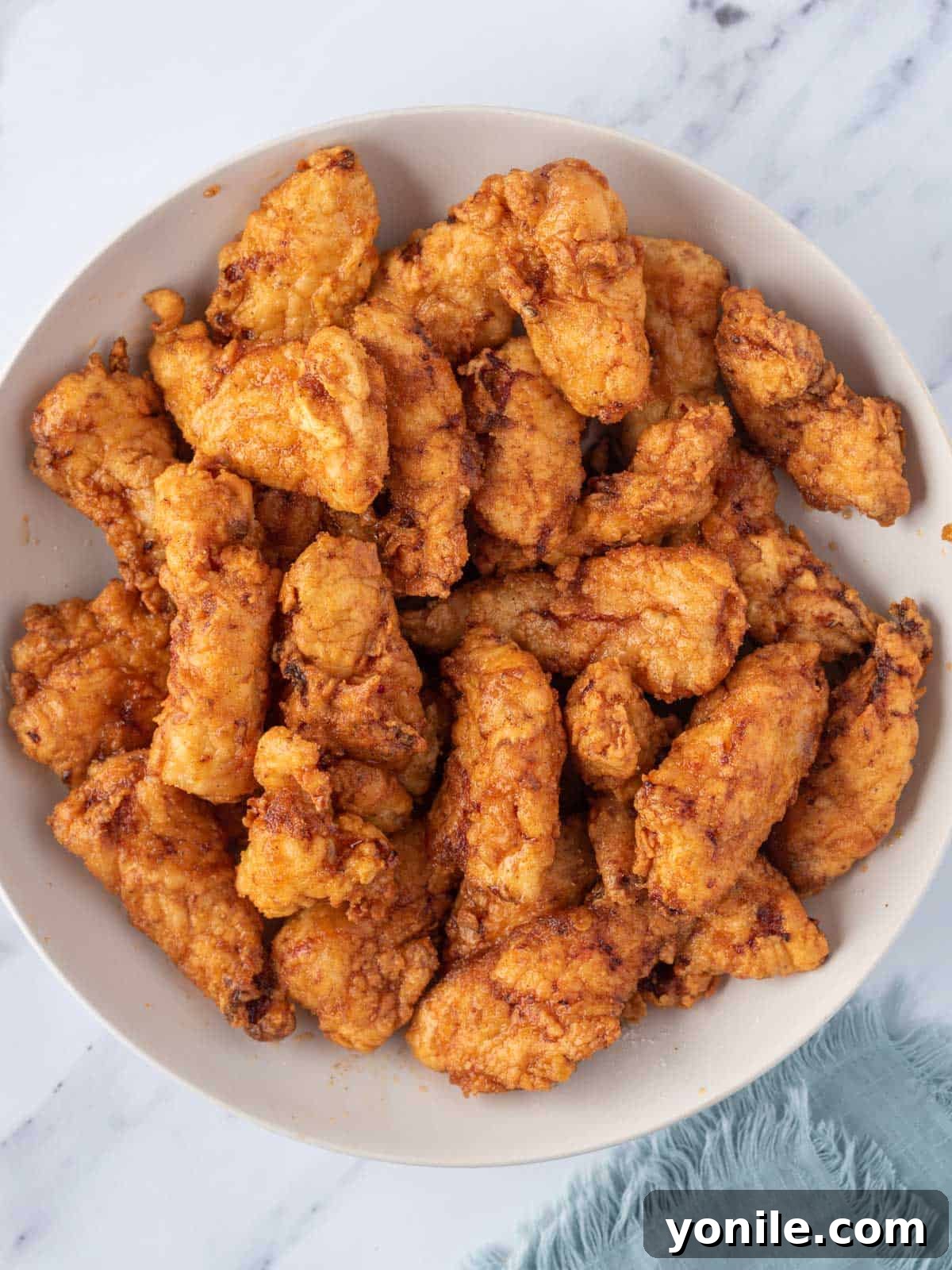KFC's Fiery Nashville Tenders 8 A large bowl containing Nashville hot chicken tenders coated in sauce.