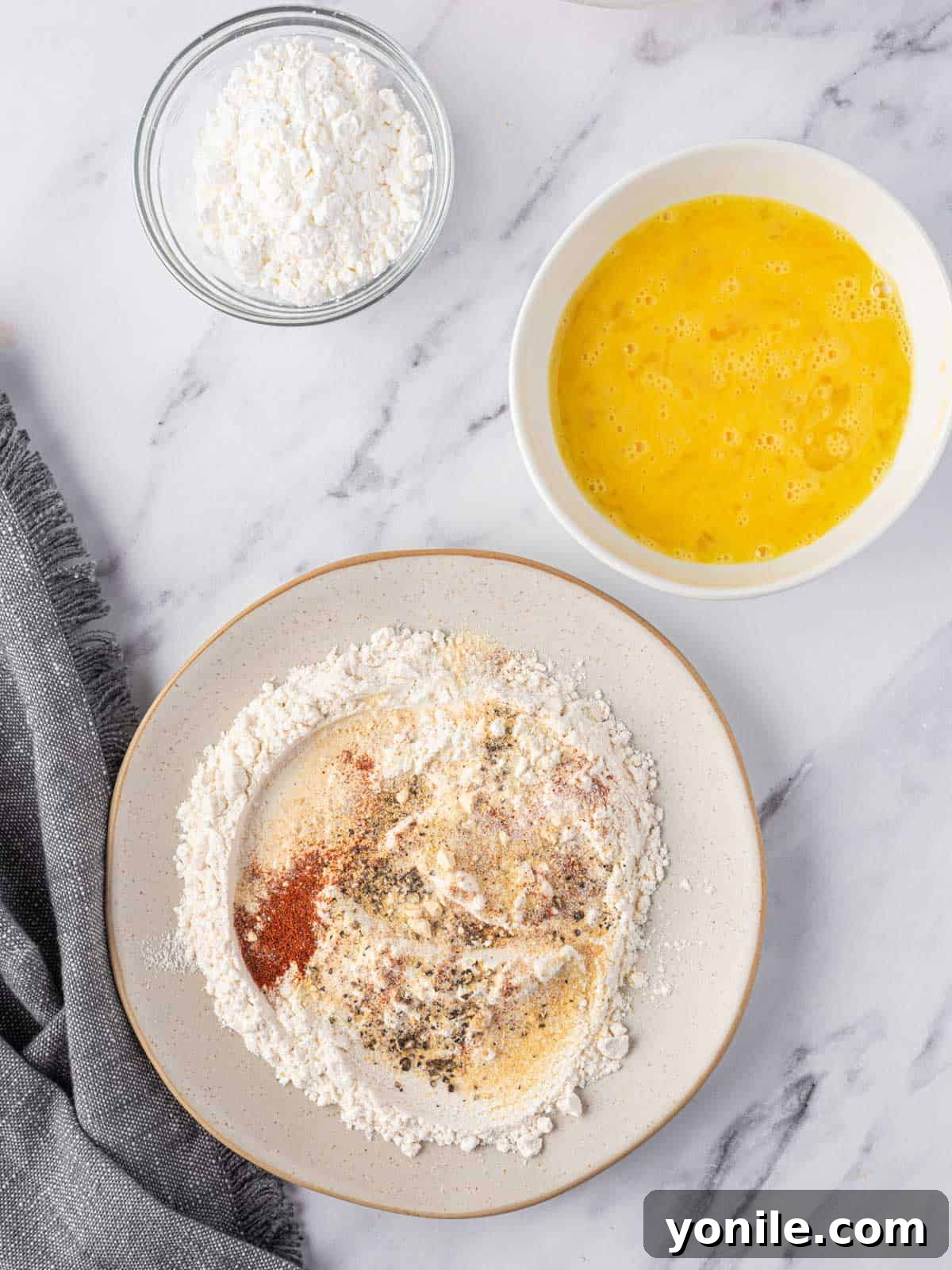 Golden Air Fryer Chicken Bites 5 Bowls of seasoned flour, egg and cornstarch for dredging chicken nuggets.