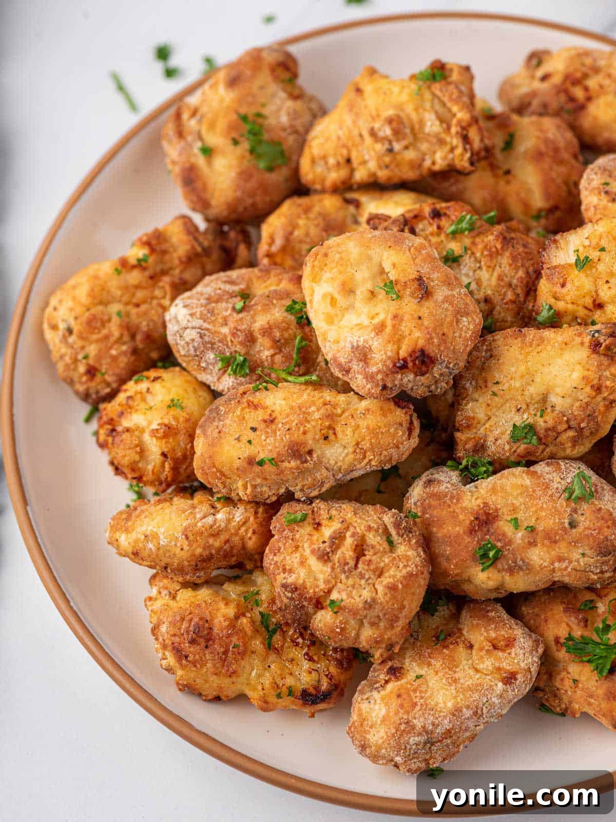 Golden Air Fryer Chicken Bites 10 Air fryer popcorn chicken in a bowl.