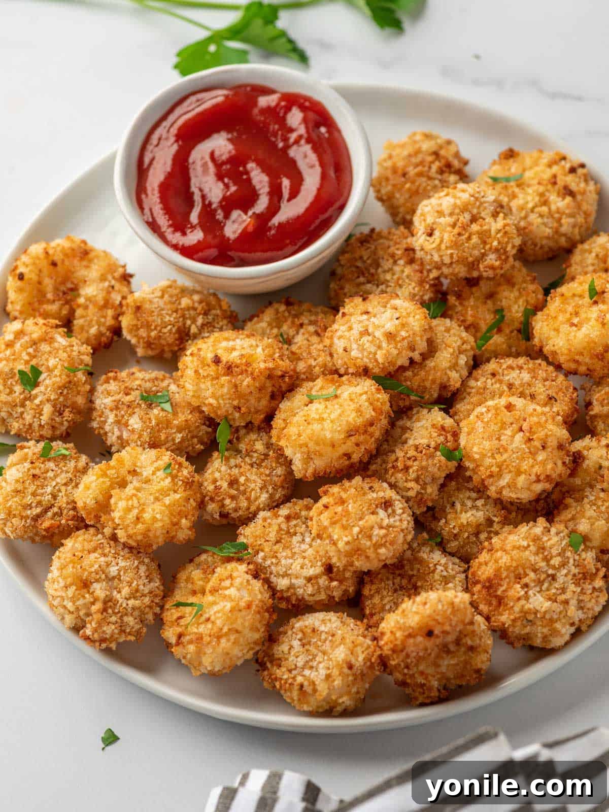 A white tray with popcorn shrimp air fryer and cocktail sauce.