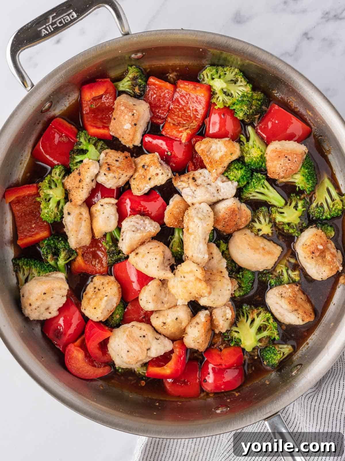 A skillet with Chicken, veggies and chicken stir fry sauce.