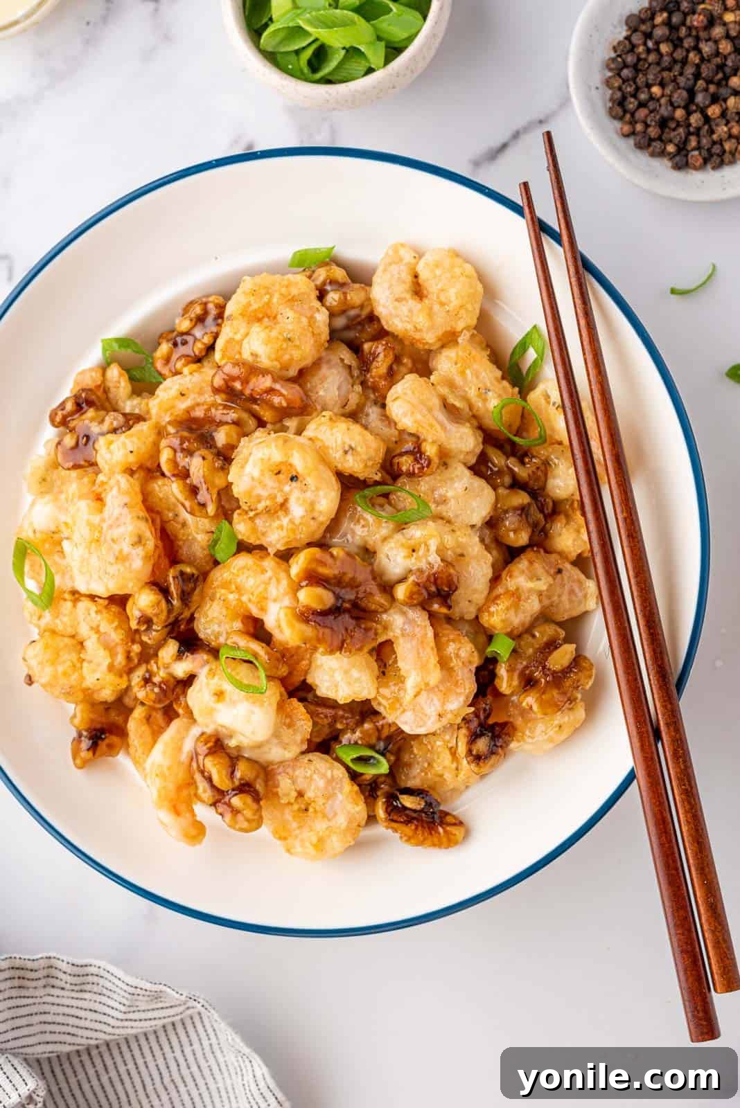Golden Honey Walnut Shrimp 2 Walnut shrimp in a bowl with a pair of chopsticks.