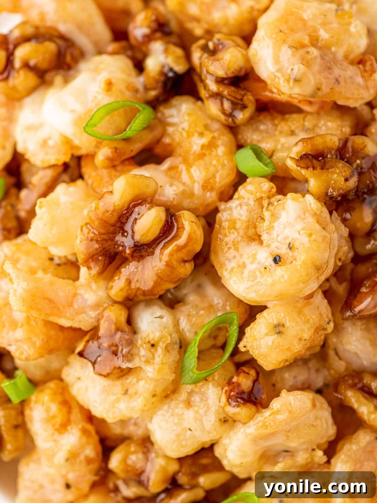 Golden Honey Walnut Shrimp 10 A pile of sweet honey shrimp with walnuts and green onions.
