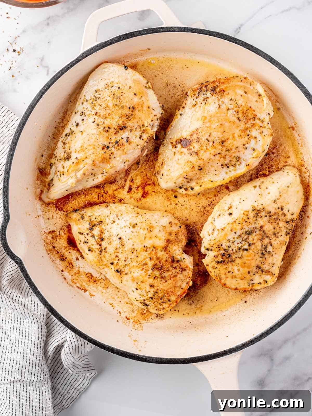 Chicken seared in a pan.
