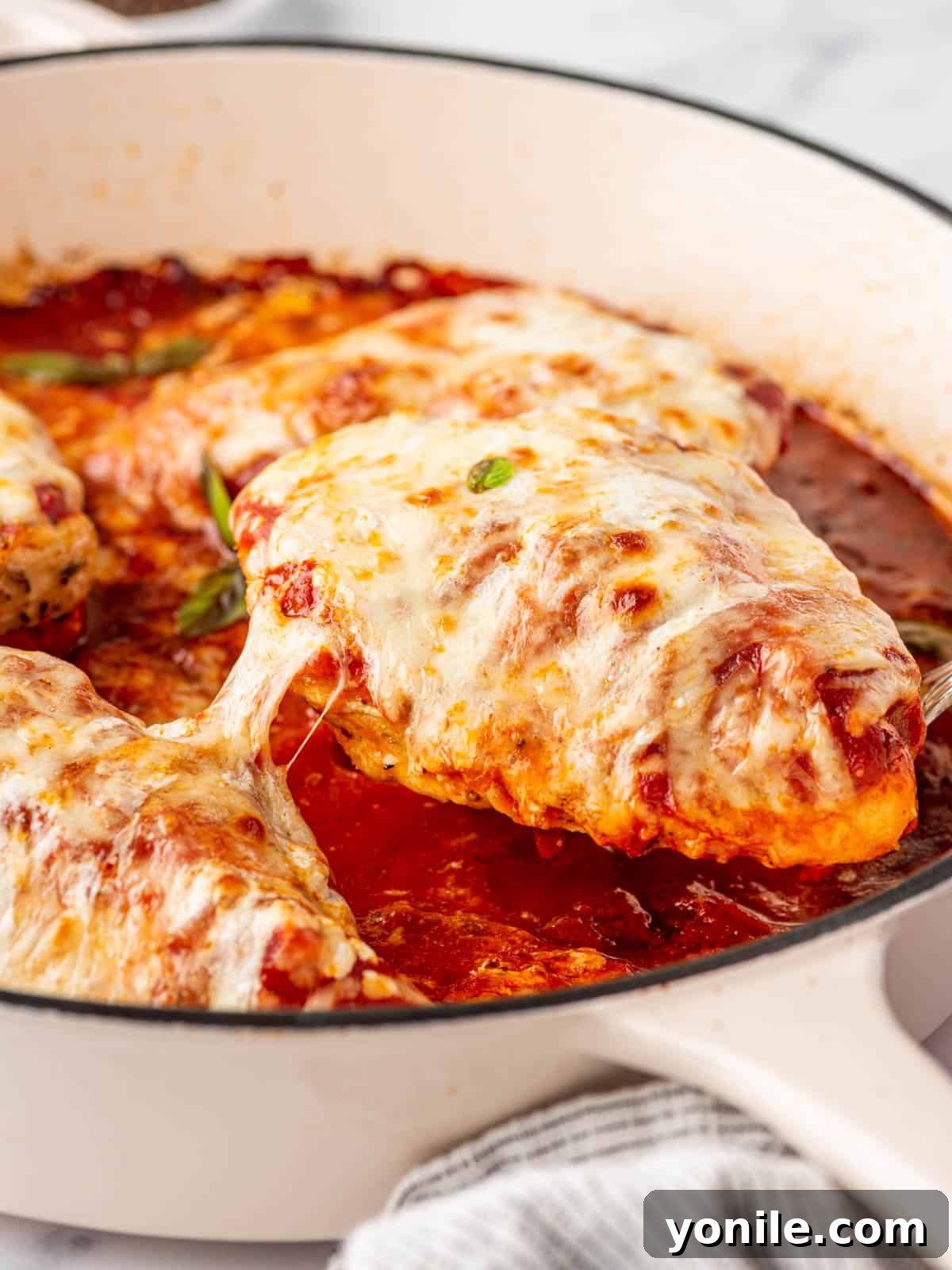 A pan with low carb chicken parmesan lifted from the pan.