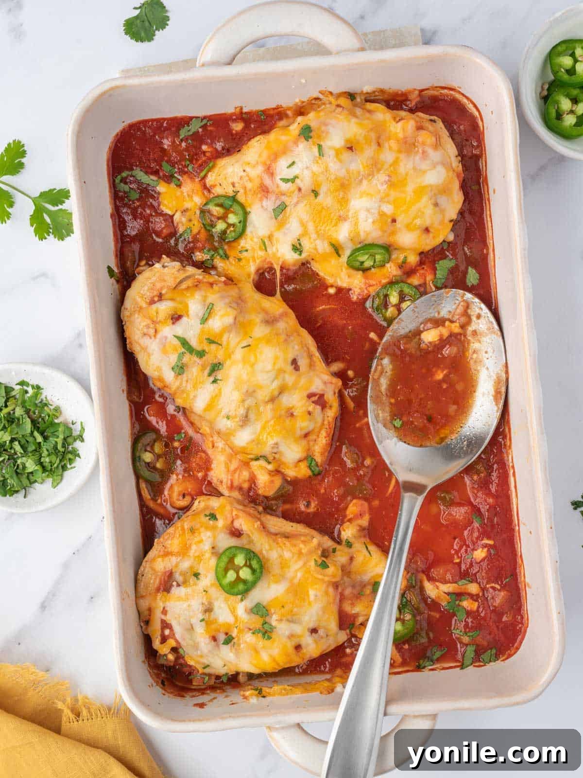 A baking dish with baked salsa chicken.