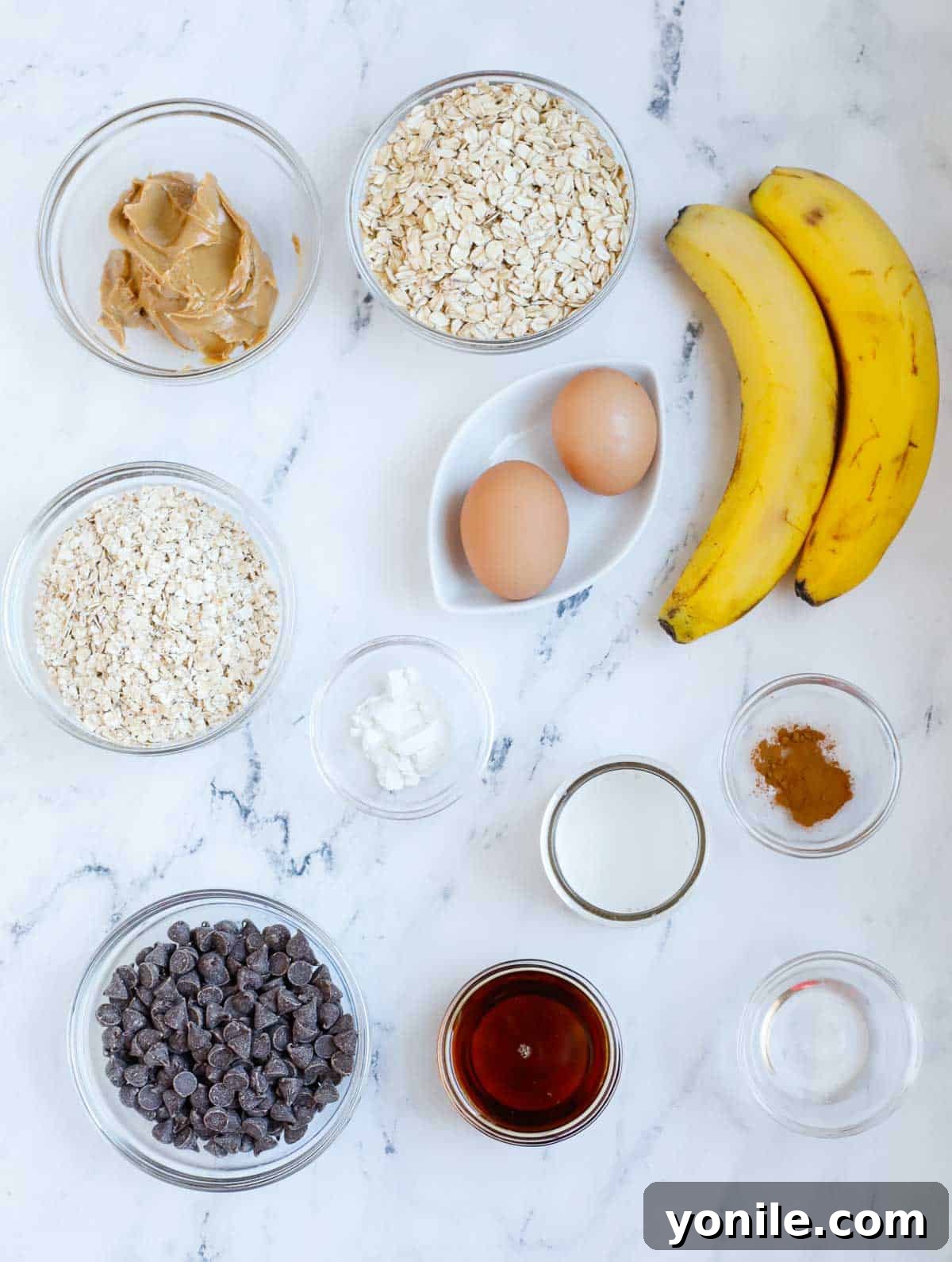 Chocolate Chip Oat Delight 3 A collection of fresh ingredients laid out on a kitchen counter, including oats, bananas, peanut butter, chocolate chips, and other staples, ready for making chocolate chip baked oatmeal.