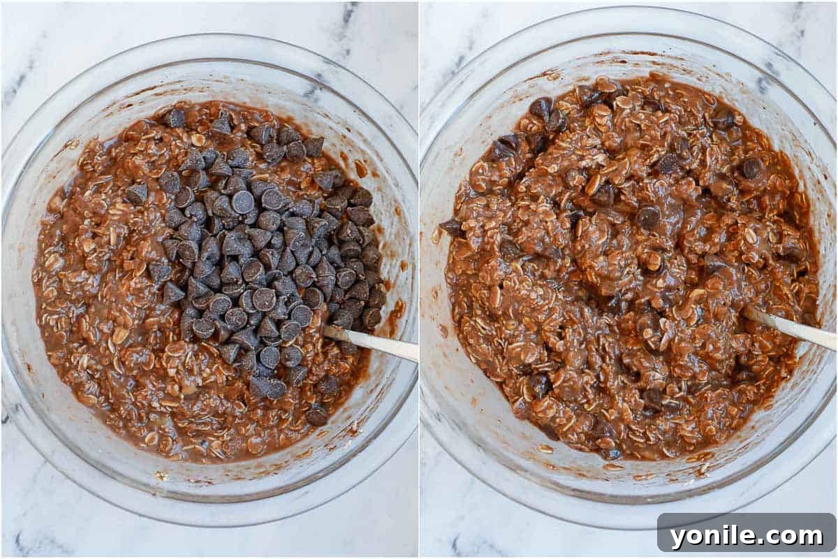 The batter for baked chocolate oats being mixed with added chocolate chips, illustrating the final stage before baking.