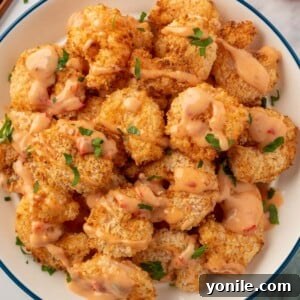 A pile of air fryer panko shrimp with bang bang sauce.
