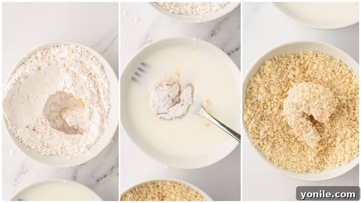 Hands demonstrating the coating process for shrimp, first dredging in a cornstarch mixture, then dipping in buttermilk, and finally coating in panko breadcrumbs.