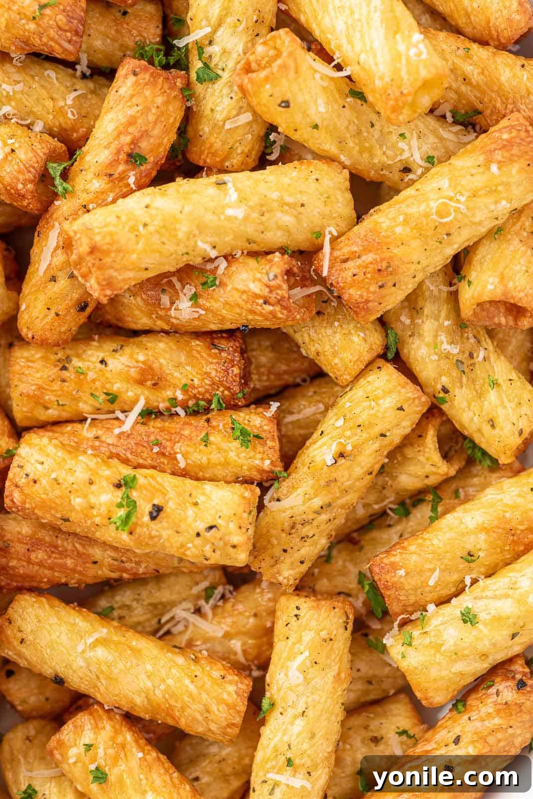 Closeup of crispy fried pasta chips on a white plate.