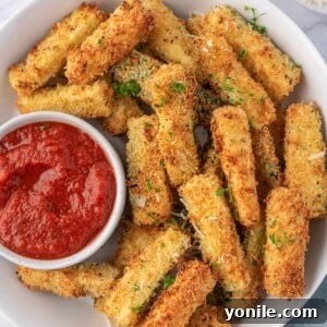 Crispy Air Fryer Zucchini Sticks 10 Air fryer zucchini sticks on a plate with a bowl of marinara.
