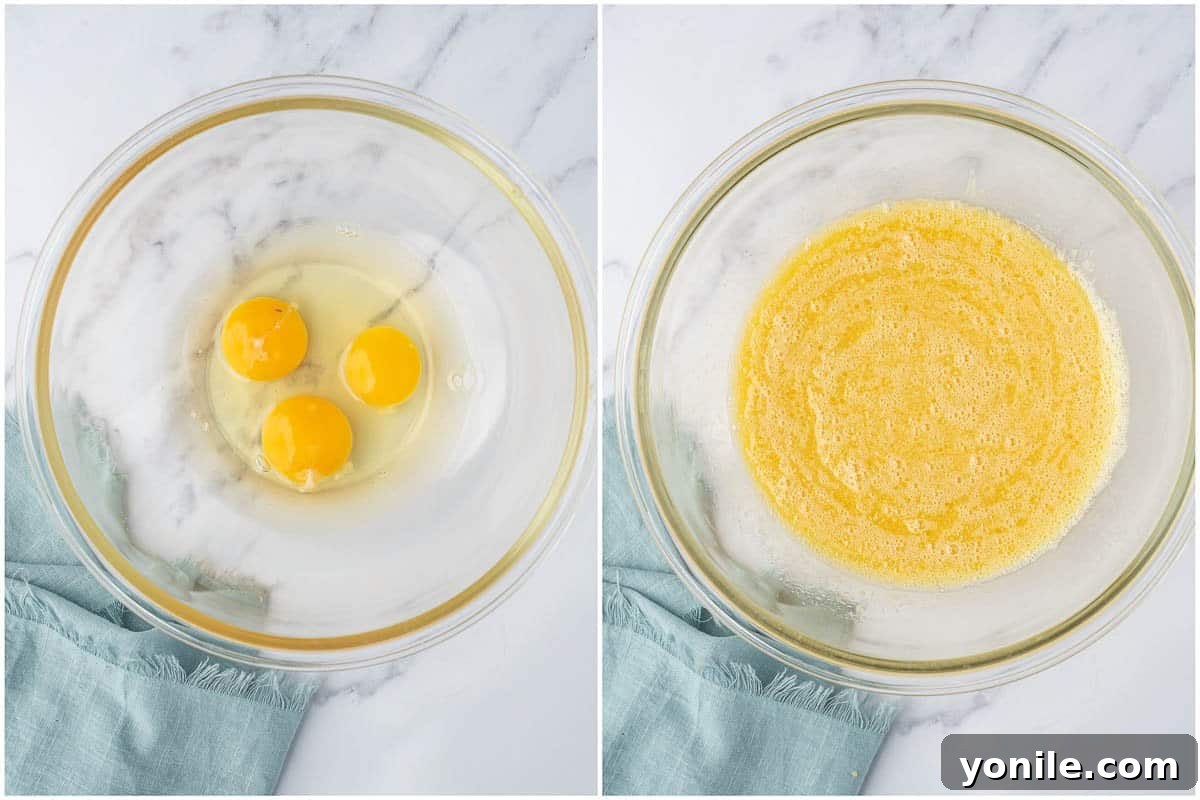 Close-up shot of beaten eggs in a mixing bowl, showcasing their smooth, frothy texture before other ingredients are added.