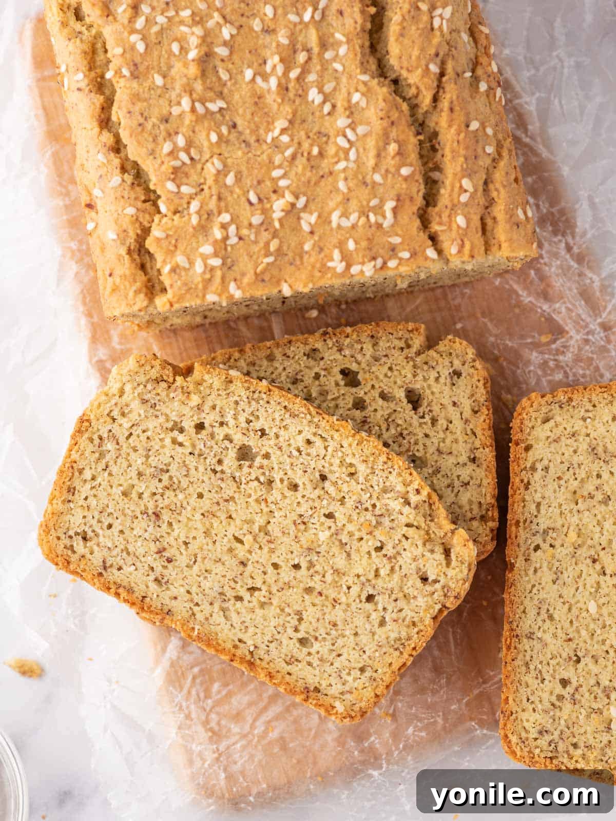 Guilt-Free Keto Sandwich Loaf 7 A loaf of keto sandwich bread with several slices of bread rest on a bread board.