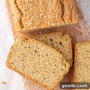Guilt-Free Keto Sandwich Loaf 10 A loaf of keto sandwich bread with several slices of bread rest on a bread board.